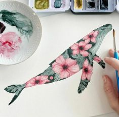 someone is painting a fish with flowers on it