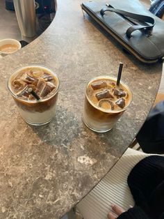 two iced drinks sitting on top of a table