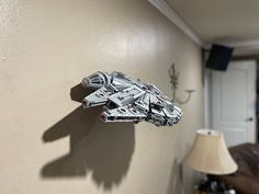 a star wars model is mounted to the side of a wall next to a lamp