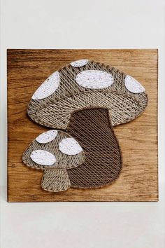 A large and small mushroom made in string art using dark and light brown tone string on a piece of stained wood. Mail And Thread Art, Nail And Yarn Art Designs, Highland Cow String Art, Mushroom String Art, Nail String Art Patterns, String Crafts Ideas, Thread Art On Wood, Nail And String Art Patterns, Nail String Art Template