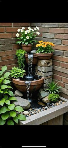 a water fountain surrounded by plants and rocks in front of a brick wall with text overlay