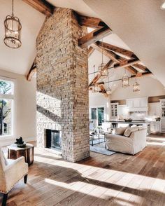 a living room filled with furniture and a fire place in the middle of an open floor plan