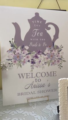 a welcome sign for a bridal shower with flowers and teapots on it