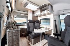 an interior view of a camper with the kitchen and dinning area in it