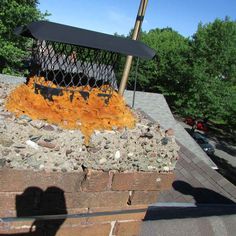 a fire pit with an umbrella sticking out of it's top and rocks surrounding it