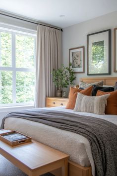 a bedroom with a bed, nightstands and pictures hanging on the wall above it