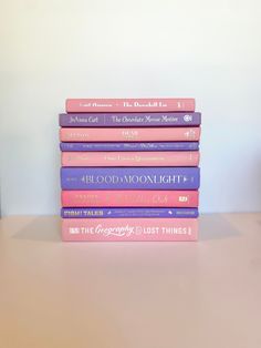 a stack of books sitting on top of a wooden table