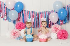 two babies are sitting in front of some cupcakes and balloons on the floor