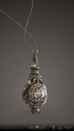 an ornate silver vase hanging from a chain on a gray background with the words hogwarts written below it