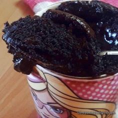 a cup filled with chocolate cake on top of a wooden table