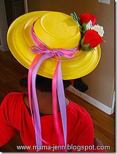 a woman wearing a yellow hat with flowers on it