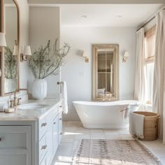 a bathroom with a tub, sink and mirror