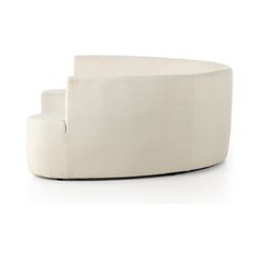 a white couch sitting on top of a white floor next to a chair and ottoman