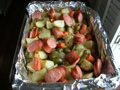 a pan filled with meat and vegetables covered in tin foil