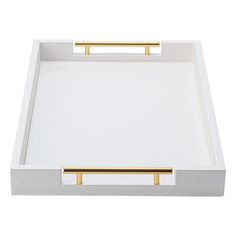 an empty white tray with gold handles