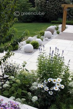 an outdoor garden with white rocks and flowers