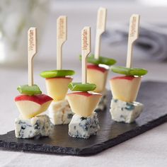 small appetizers with cheese and apple slices on a black slate platter, ready to be eaten