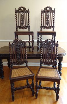 four wooden chairs sitting on top of a hard wood floor