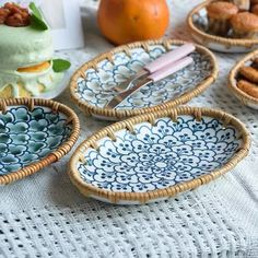 four blue and white dishes on a table with oranges in the backgroud