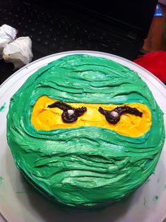 a cake with green frosting and yellow icing on top of a white plate