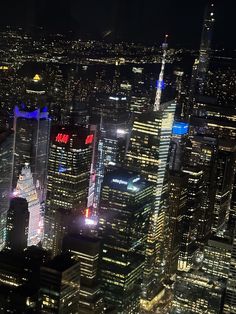 an aerial view of the city at night with skyscrapers lit up in red, white and blue