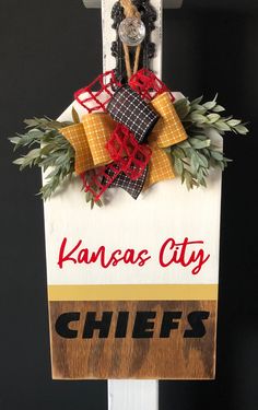 the kansas city chiefs sign is adorned with wreaths and bows, as well as an ornament