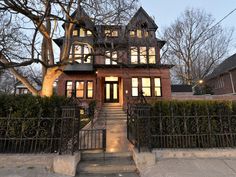 an old victorian style house with wrought iron fence