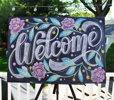 a chalkboard sign with the words welcome painted on it