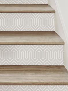 the stairs are painted with white and beige geometric wallpaper