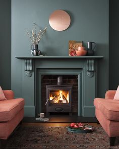 a living room with two chairs and a fire place in the middle of the room