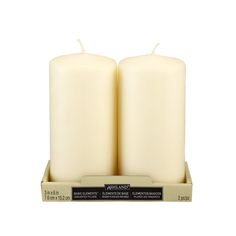 two white candles sitting on top of each other