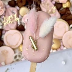 a close up of a pink and white cake on a toothpick with a feather