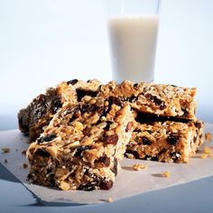 granola bars stacked on top of each other next to a glass of milk