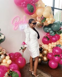 a woman standing in front of balloons and flowers