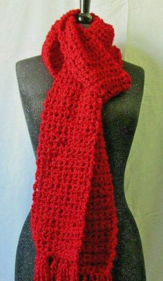 a red crocheted scarf hanging on a mannequin