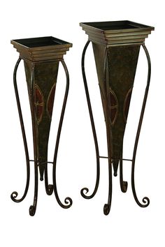 two tall metal plant stands sitting next to each other on top of a white background