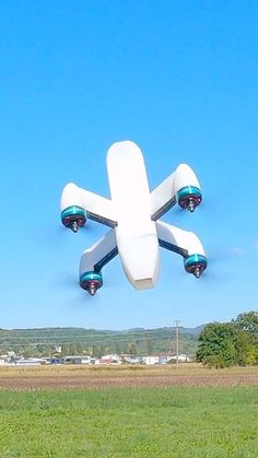 a large white airplane flying over a lush green field