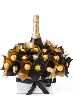 a bottle of champagne and some chocolates in a gift box with ribbon around it