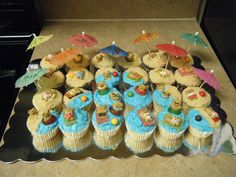 there are many cupcakes that have been decorated with animals and umbrellas on them