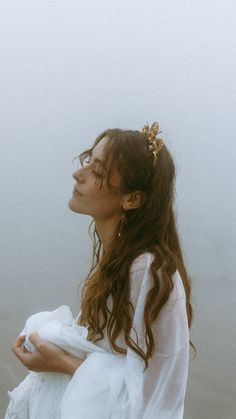 a woman with long hair standing on the beach