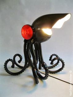 an octopus lamp with its head turned upside down on a white surface, lit by a red light