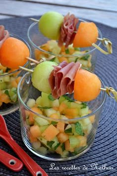 small glass bowls filled with fruit and garnish on top of a blue place mat