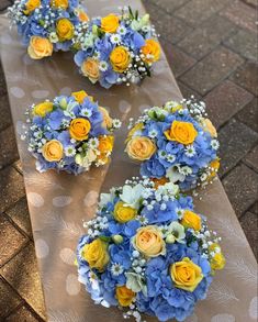 blue and yellow flowers are arranged on a long table with polka dotes in the background