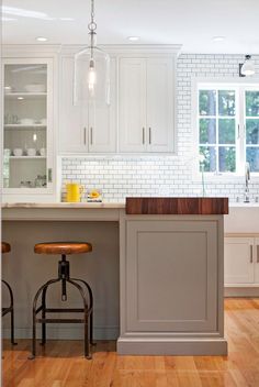 the kitchen is clean and ready to be used for cooking or baking, with stools in front of the island