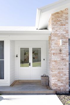 a white house with two doors and brick pillars