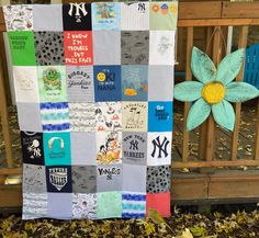 a quilt made to look like it has been placed on the ground in front of a fence