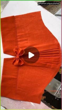 an orange piece of cloth with a bow on it