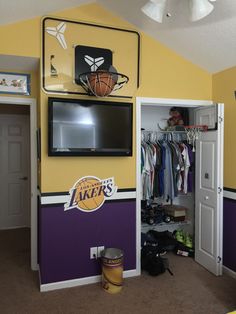 a bedroom with a basketball themed wall mounted to it's side, and an entertainment center in the corner