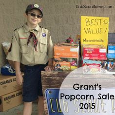 a boy scout standing in front of boxes with the caption grant's popcorn sale 2013