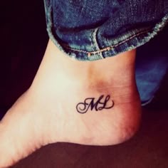 a woman's foot with a small tattoo on the ankle that reads m and l